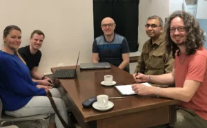 Photo of AICE Project team sitting round a desk